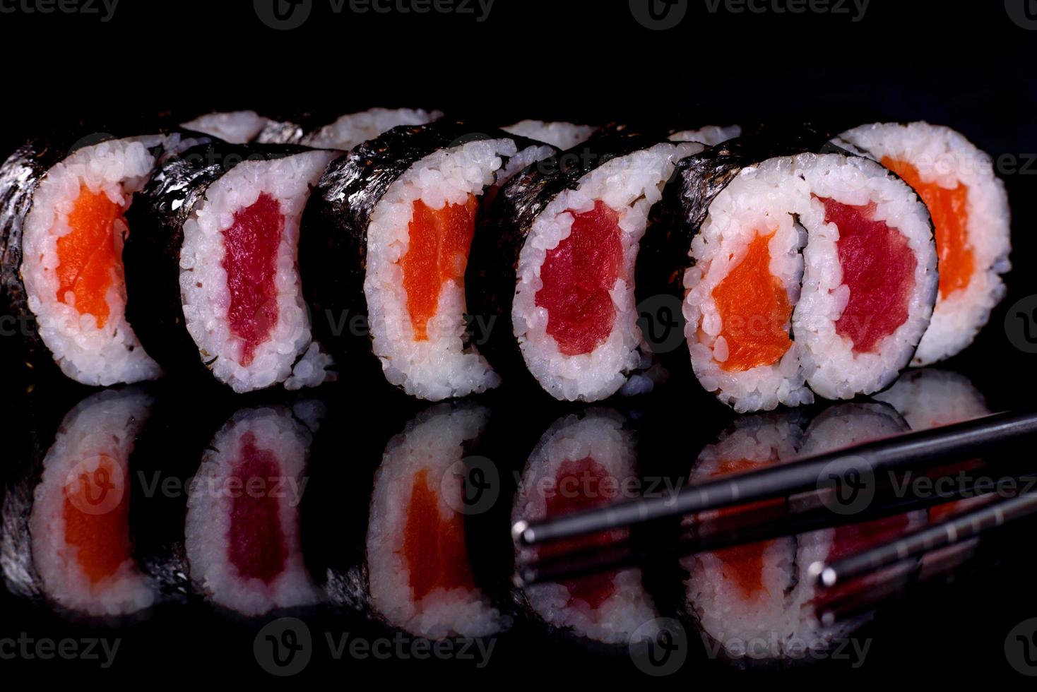 färska läckra vackra sushirullar på en mörk bakgrund foto