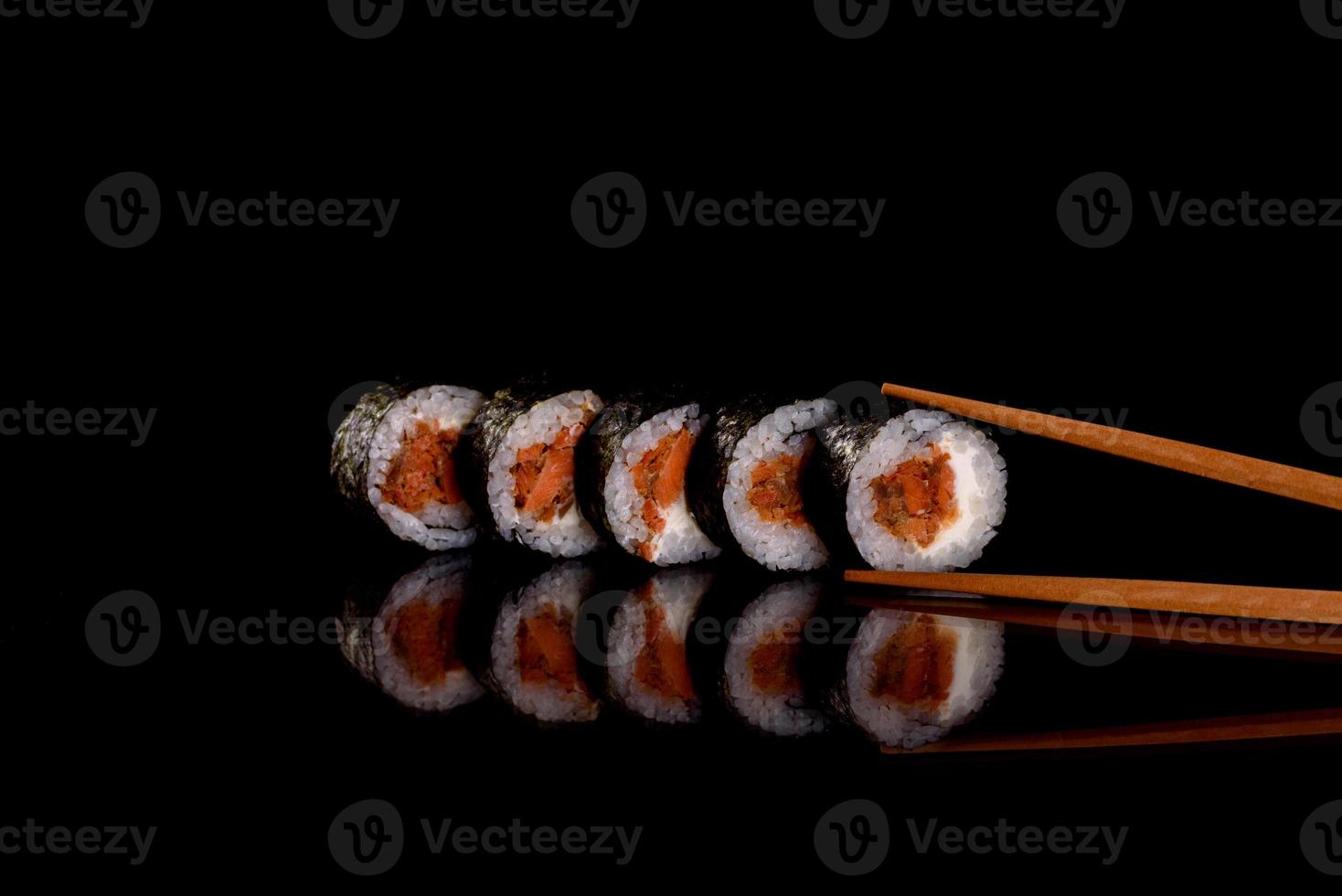 färska läckra vackra sushirullar på en mörk bakgrund foto