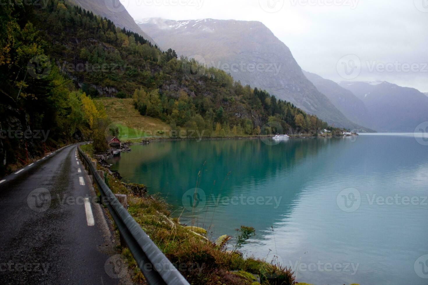 landskap i höst nära loen och stryk i norge, väg till lovatnet i oktober, sjö med turkos vatten på regnig dag foto