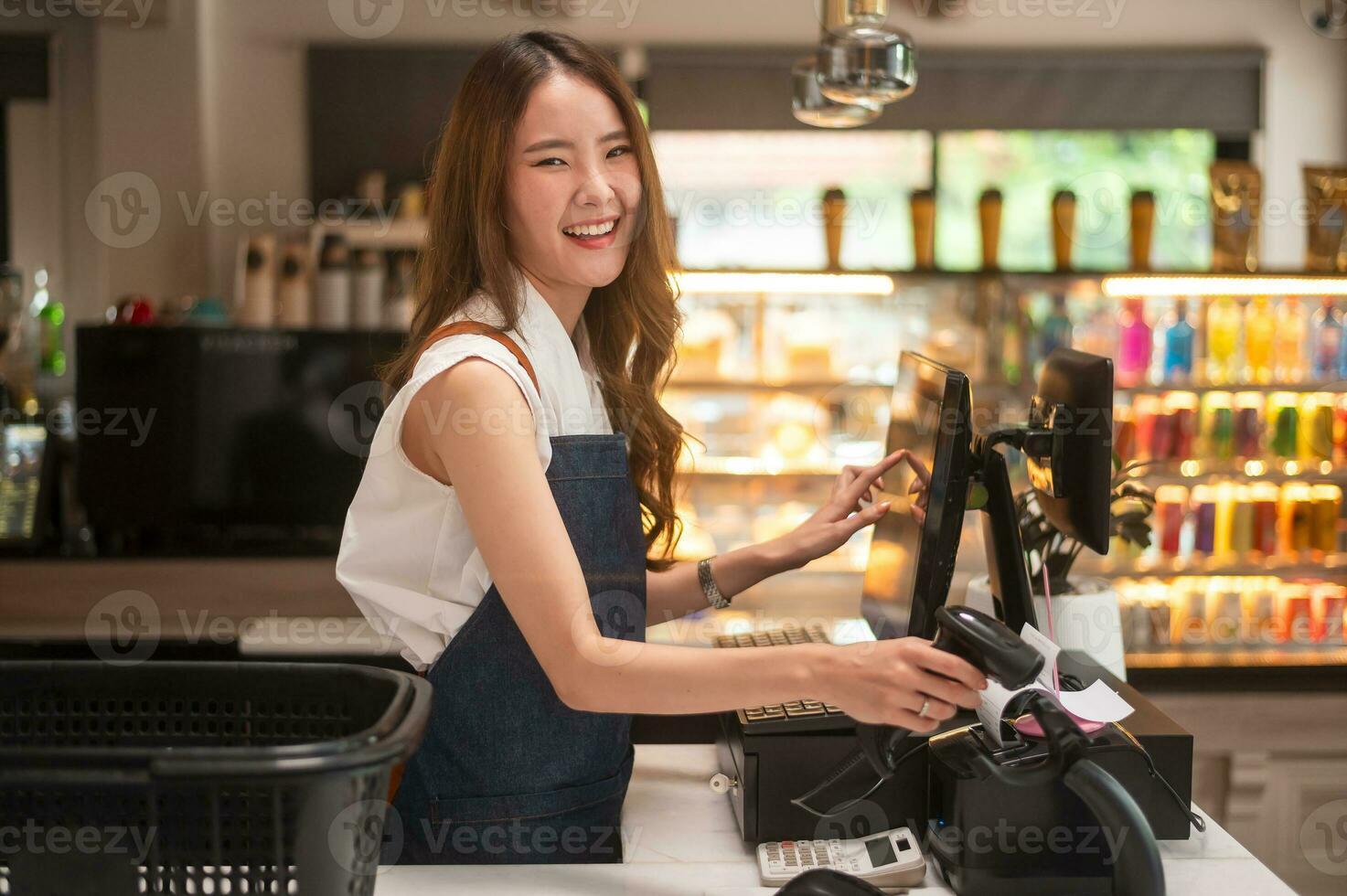 ett asiatisk ung kassör kvinna arbetssätt i mataffär foto