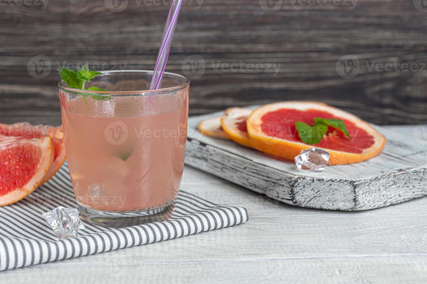 cocktail med grapefrukt på en ljus bakgrund med en myntakvist foto