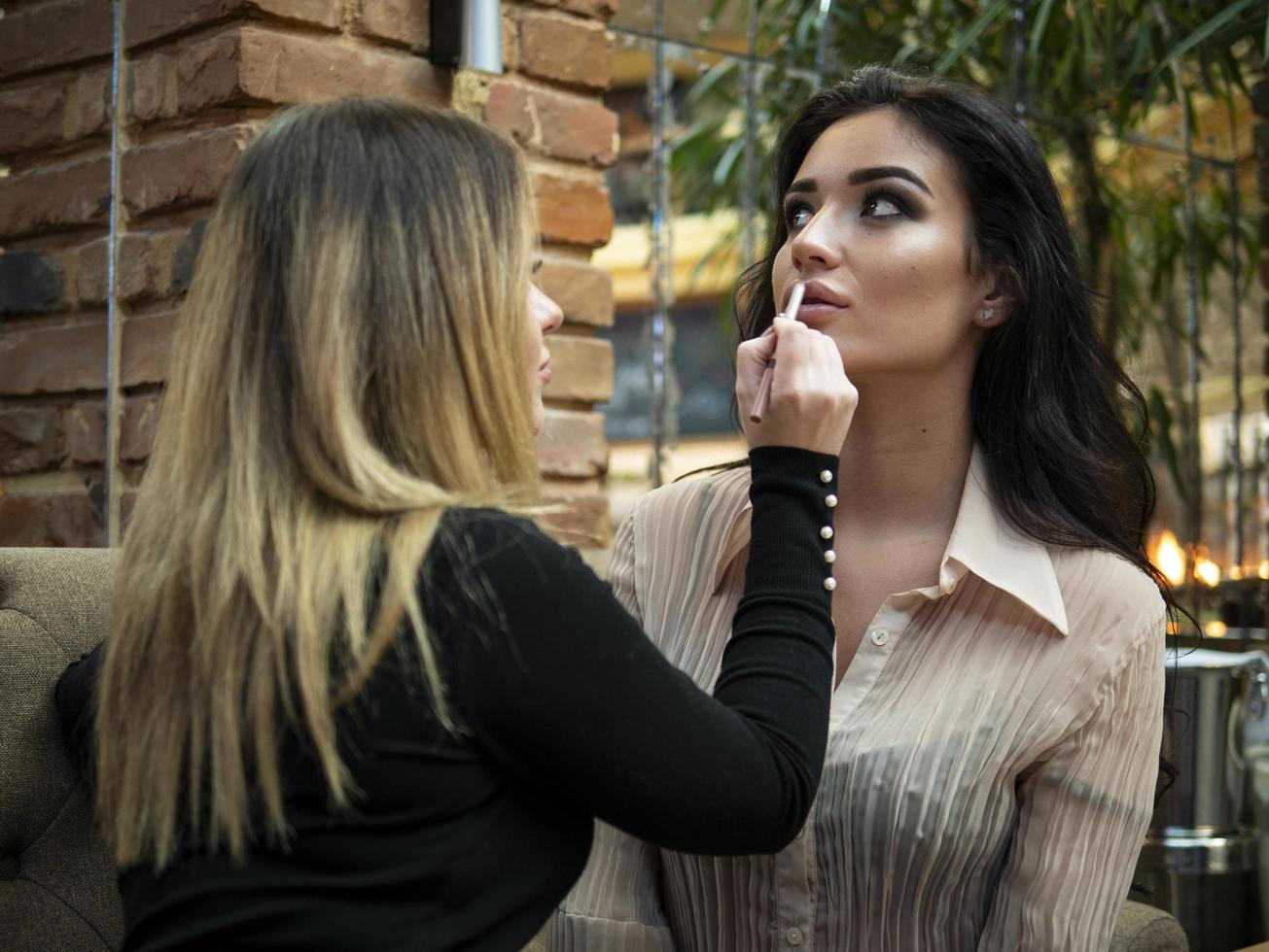 makeupartisten gör upp till den vackra unga kvinnan foto