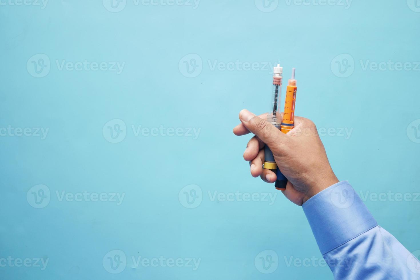 hand som håller insulinpennor med kopieringsutrymme uppifrån och ner foto