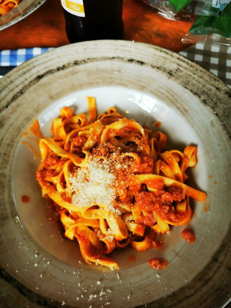 Foto av en utsökt tallrik av pasta med tomat sås och parmesan ost