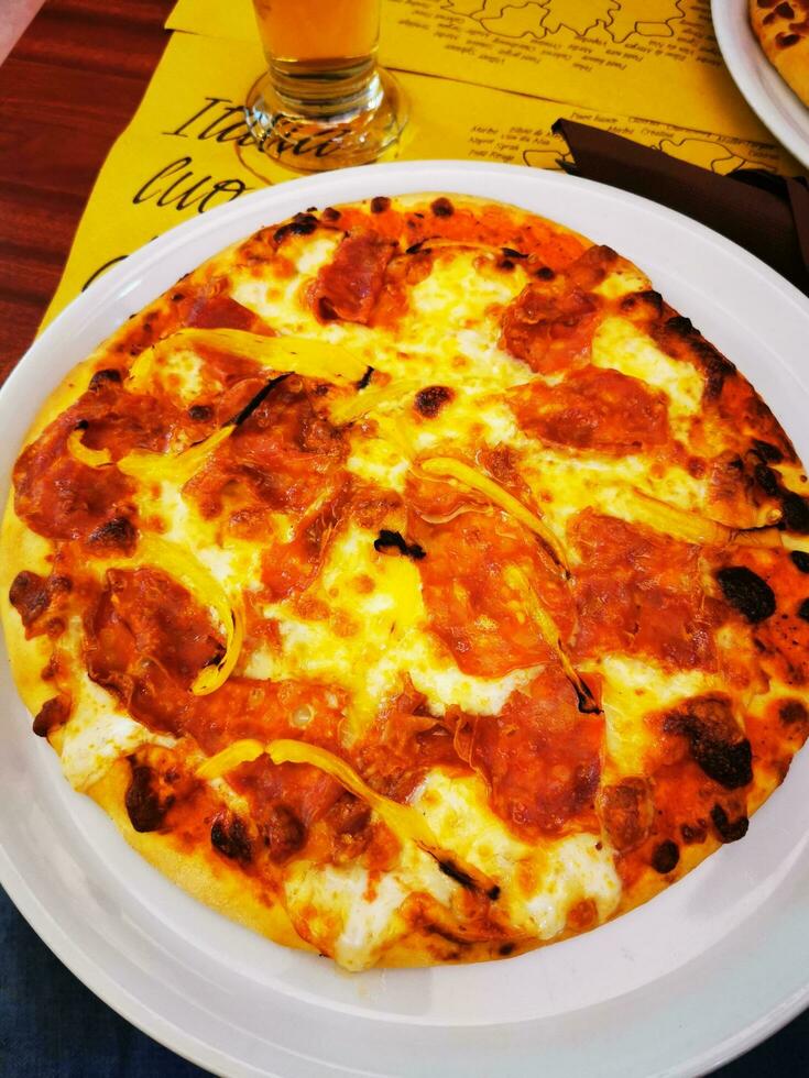 Foto av en utsökt pizza på en vit tallrik, redo till vara haft