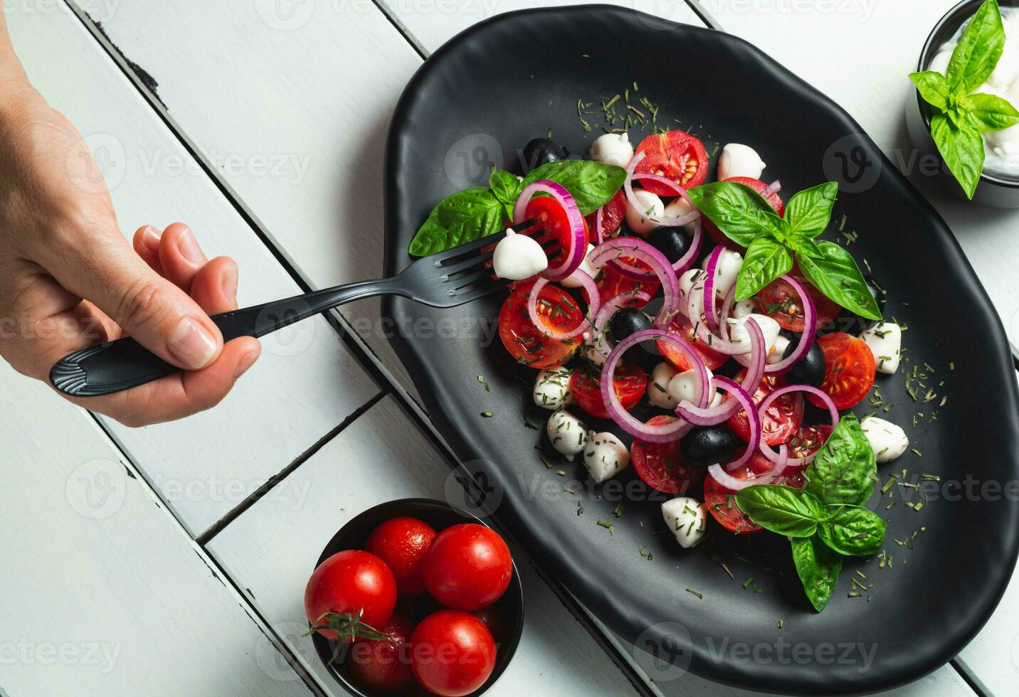 tomat och mozzarella caprese sallad och pesto sås med oliver på vit tabell eras med gaffel. mat italiensk aptitretare foto