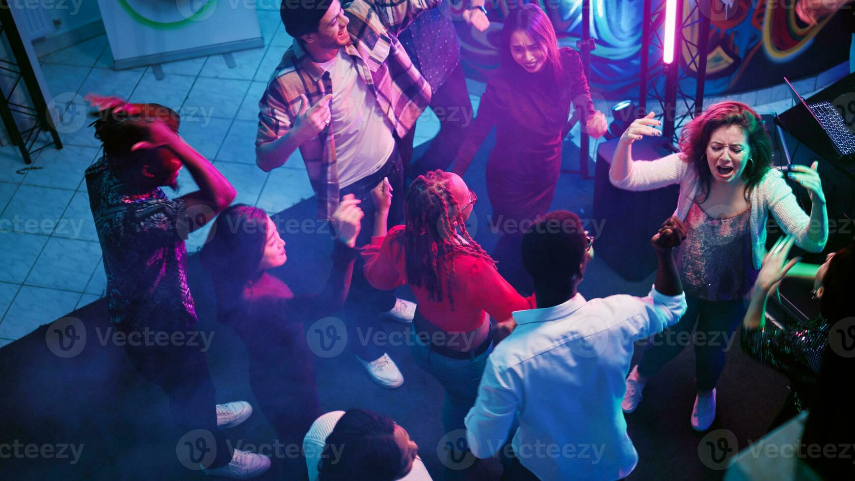 ung folkmassan av människor dans på fest, som visar skraj rör sig på diskotek händelse. glad vuxna festa på modern musik har roligt på sammankomst, njuter firande. handhållen skott. foto