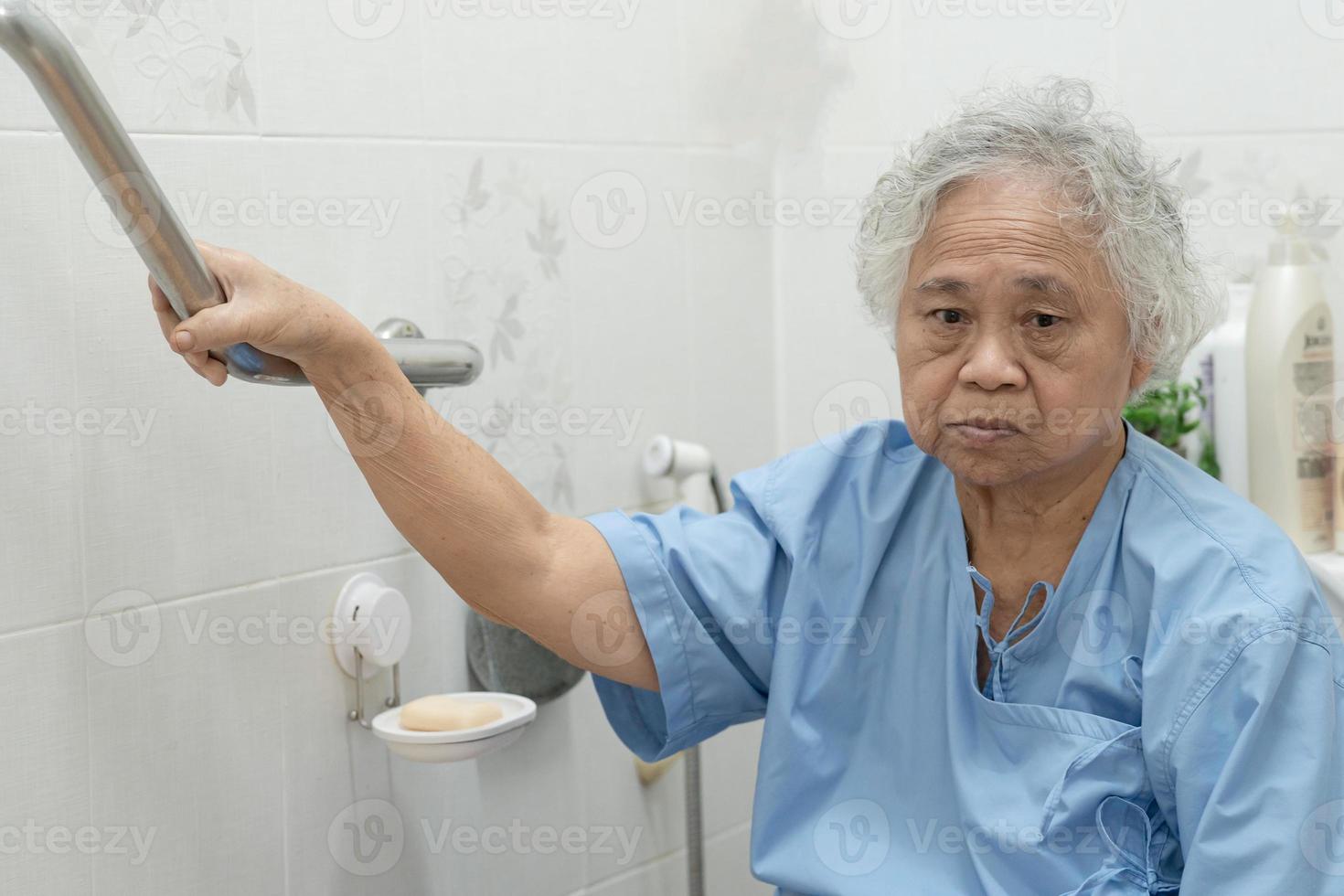 asiatisk senior kvinna patient användning hantera säkerhet i toaletten foto