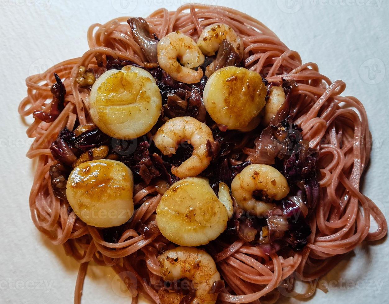 pilgrimsmusslor med röda linguine pasta örter och kryddor foto