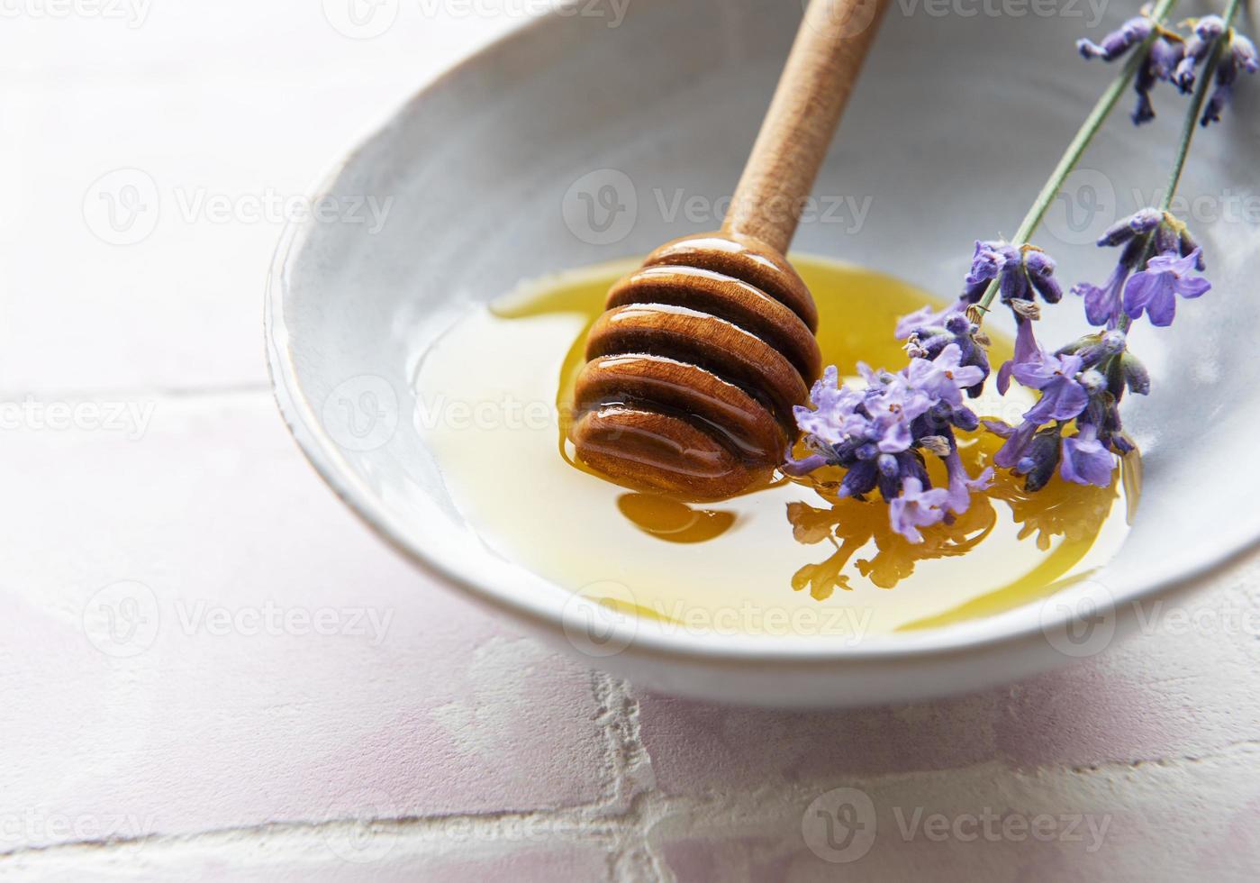 skål med honung och färska lavendelblommor foto