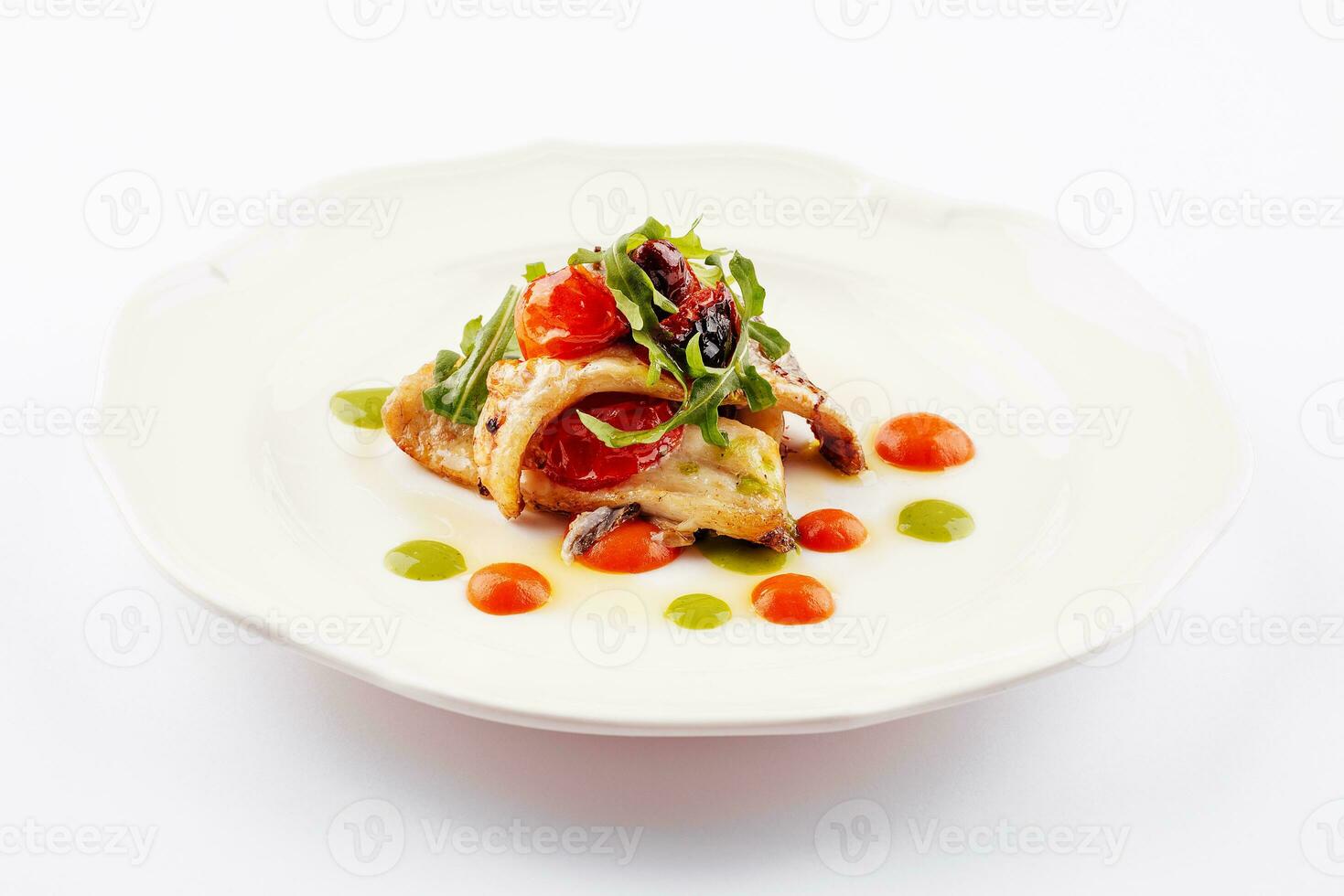 friterad vit fisk filea med tomater och arugula foto