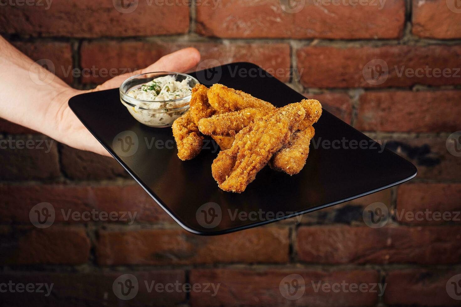 Krispig kyckling nuggets på svart tallrik foto