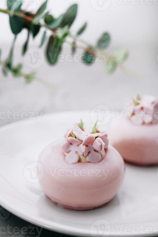 rosa mousse kakor dekorerad på vit tallrik foto