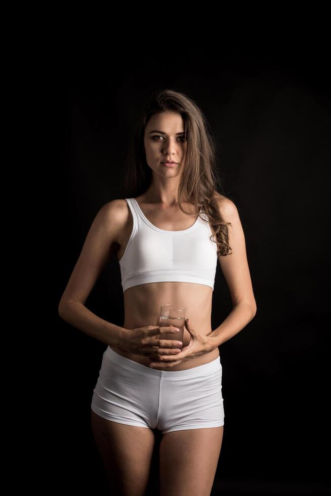 kvinnlig fitnessmodell som håller ett vattenglas foto
