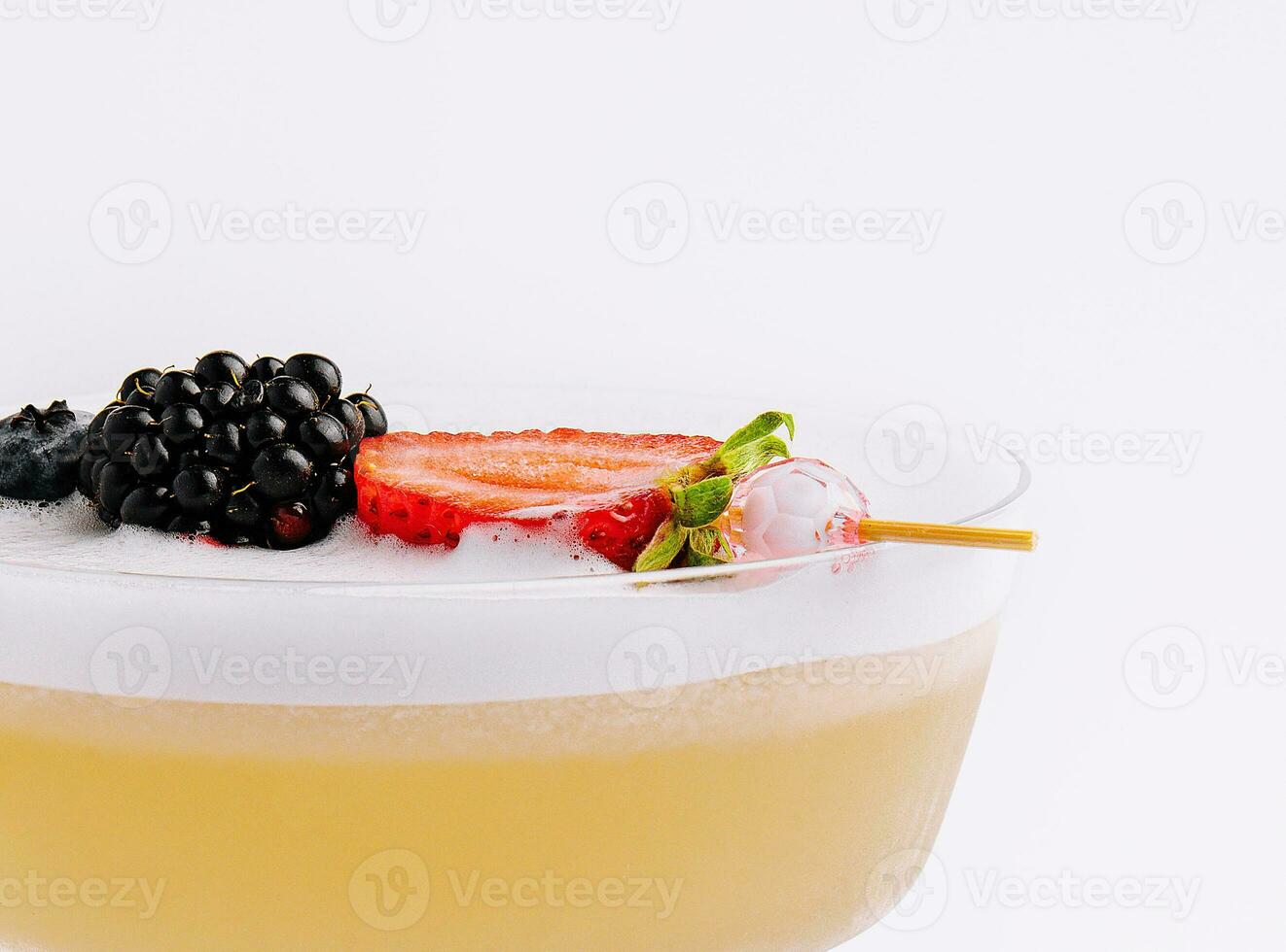 stänga upp gul cocktail med vit skum med bär foto