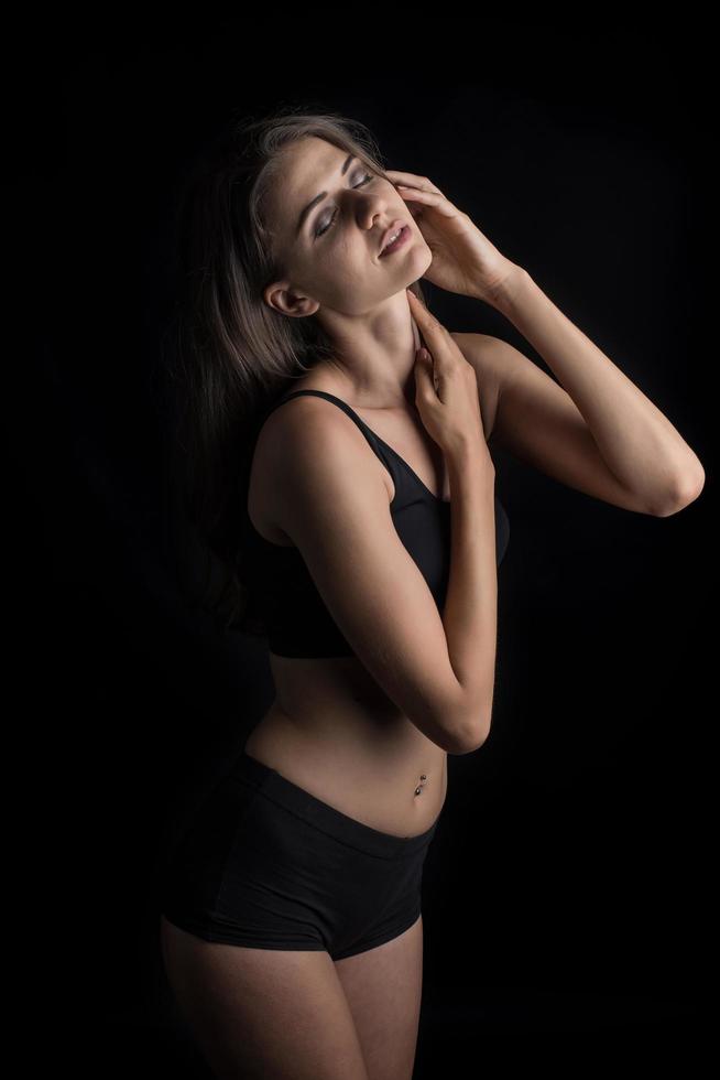 vacker kvinna med frisk kropp på svart bakgrund foto