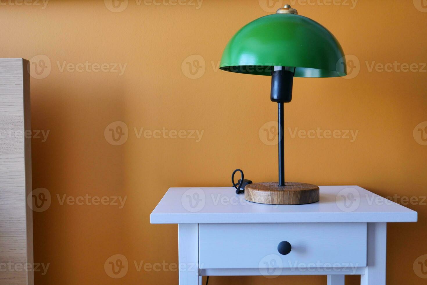 tabell lampa mot orange Färg vägg i säng rum foto
