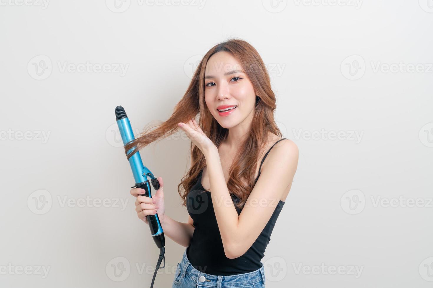 porträtt vacker asiatisk kvinna med hårkrullare eller lockjärn på vit bakgrund foto