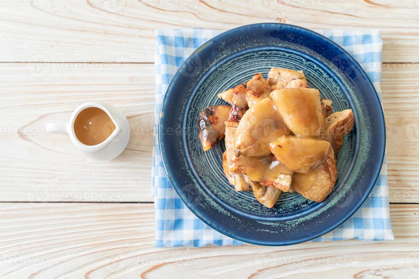 grillade bananer med kokosnötsamelsås på tallriken foto