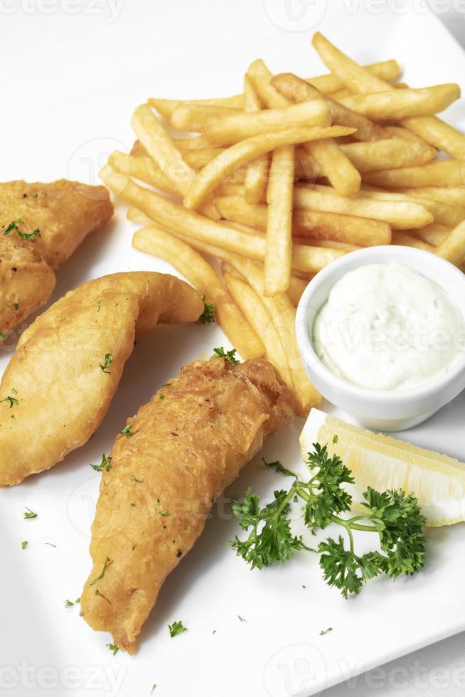 brittisk traditionell fish and chips -måltid på vit tallrik foto