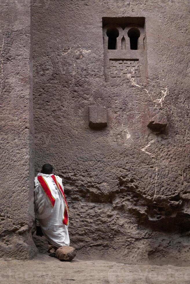 koptisk ortodox präst ber vid Lalibela gamla klipphuggna monolitiska kyrkor landmärke UNESCO-kulturarv i Etiopien foto