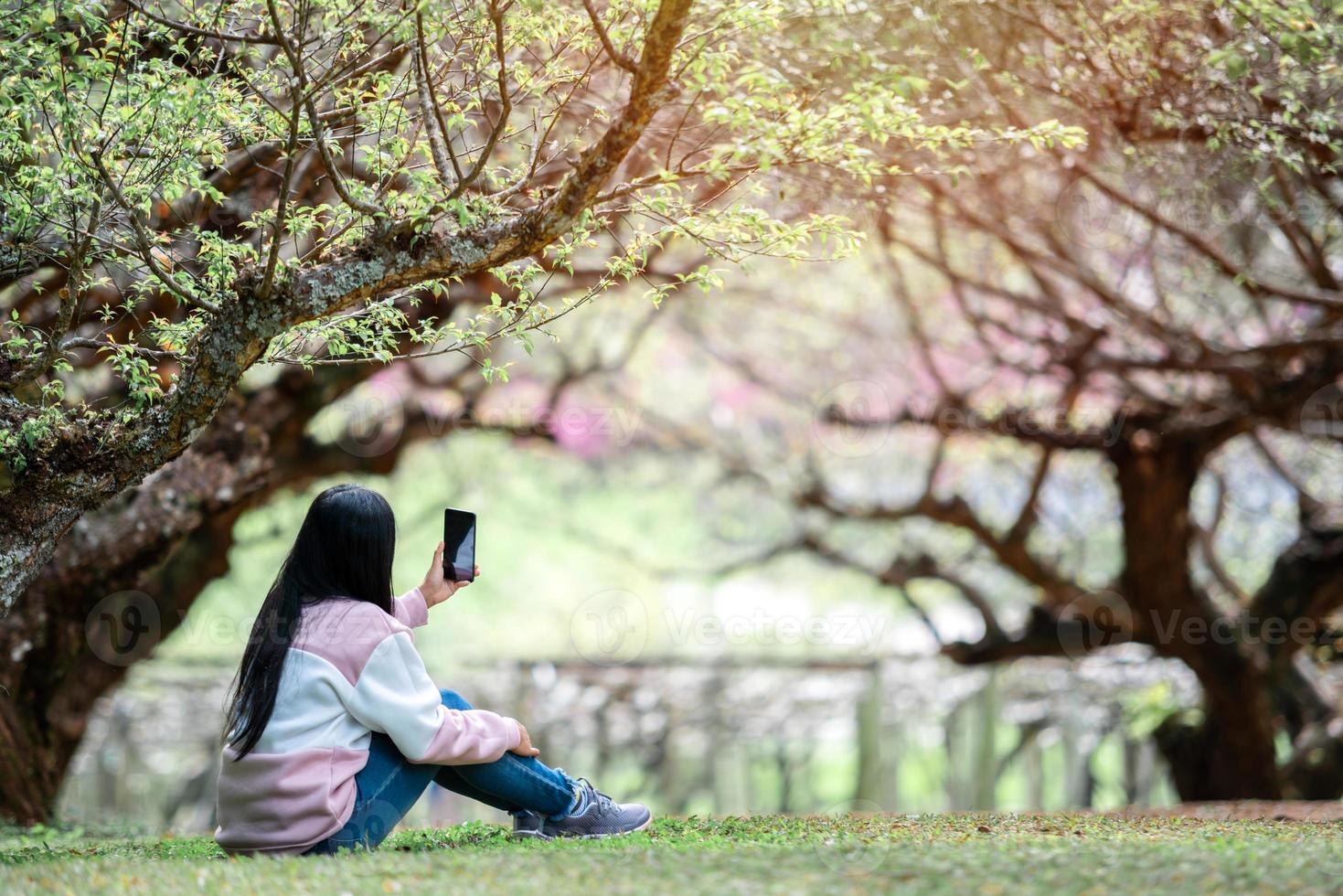 asiatisk kvinna resenär ta selfie i trädgården foto
