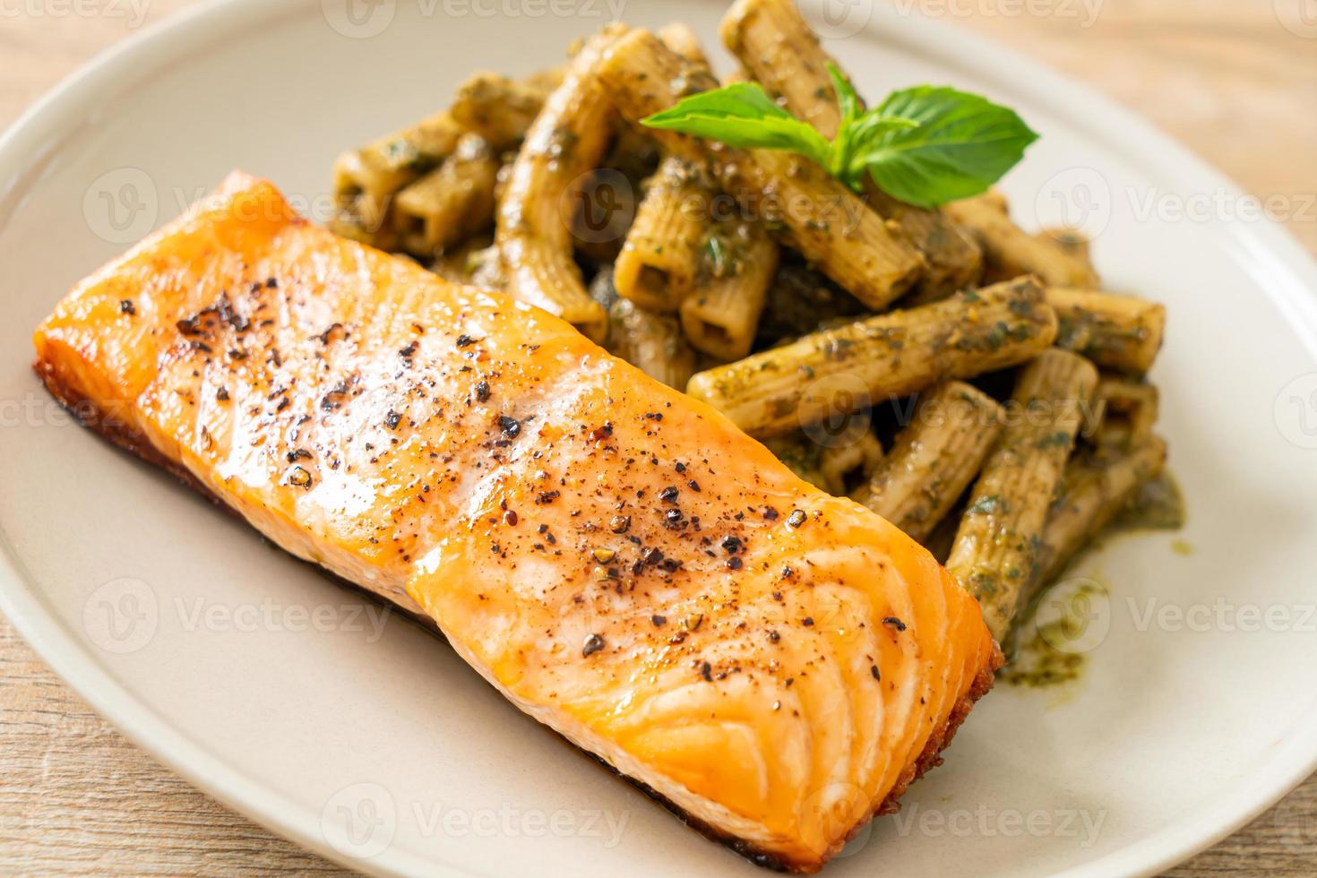 pesto quadrotto penne pasta med grillad laxfiléstek foto