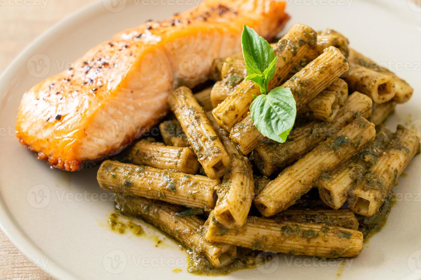 pesto quadrotto penne pasta med grillad laxfiléstek foto