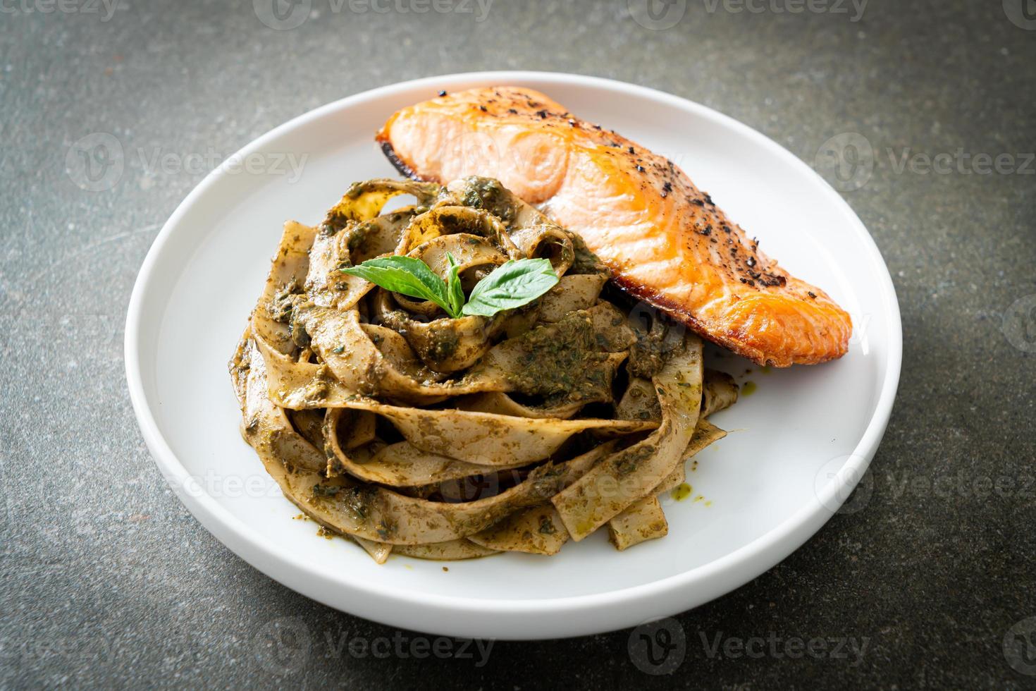 hemlagad pesto fettuccine spaghetti pasta med grillad laxfilé foto