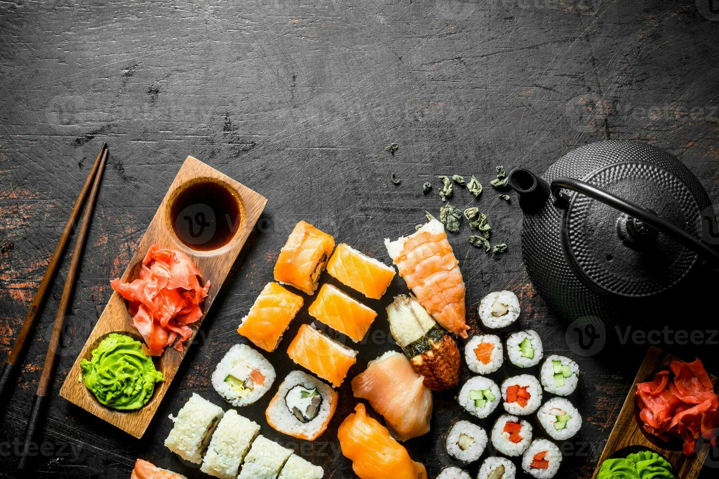 annorlunda typer av japansk sushi, rullar och maki med sås, wasabi och grön te i en tekanna. foto