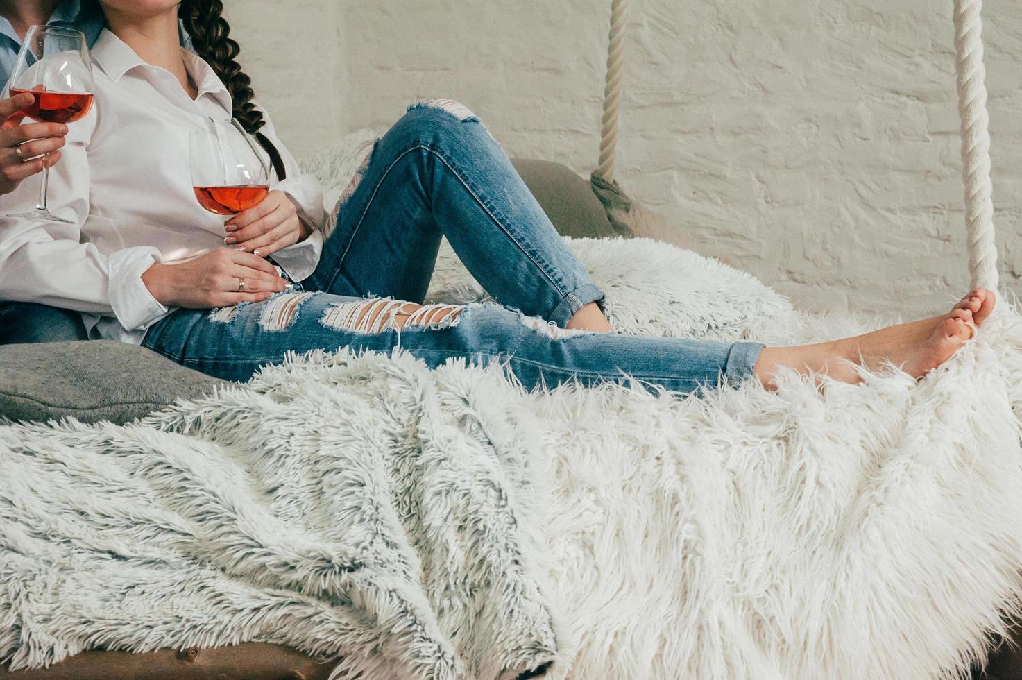 ett ungt par i jeans med vin på en säng foto