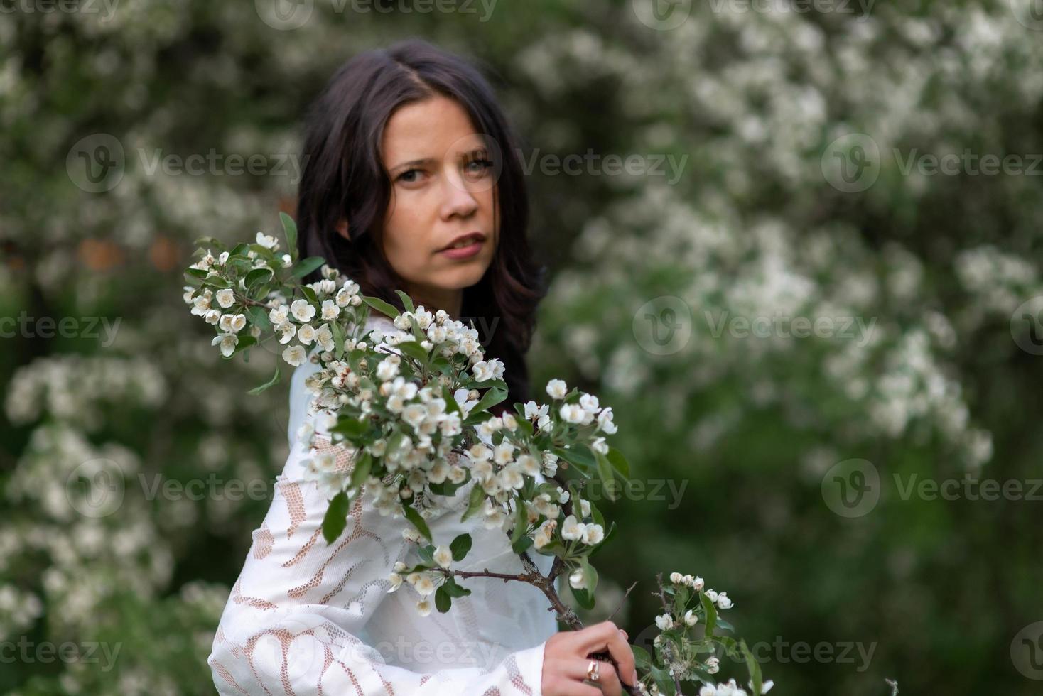 porträtt av ung kvinna i parken i de blommande grenarna foto