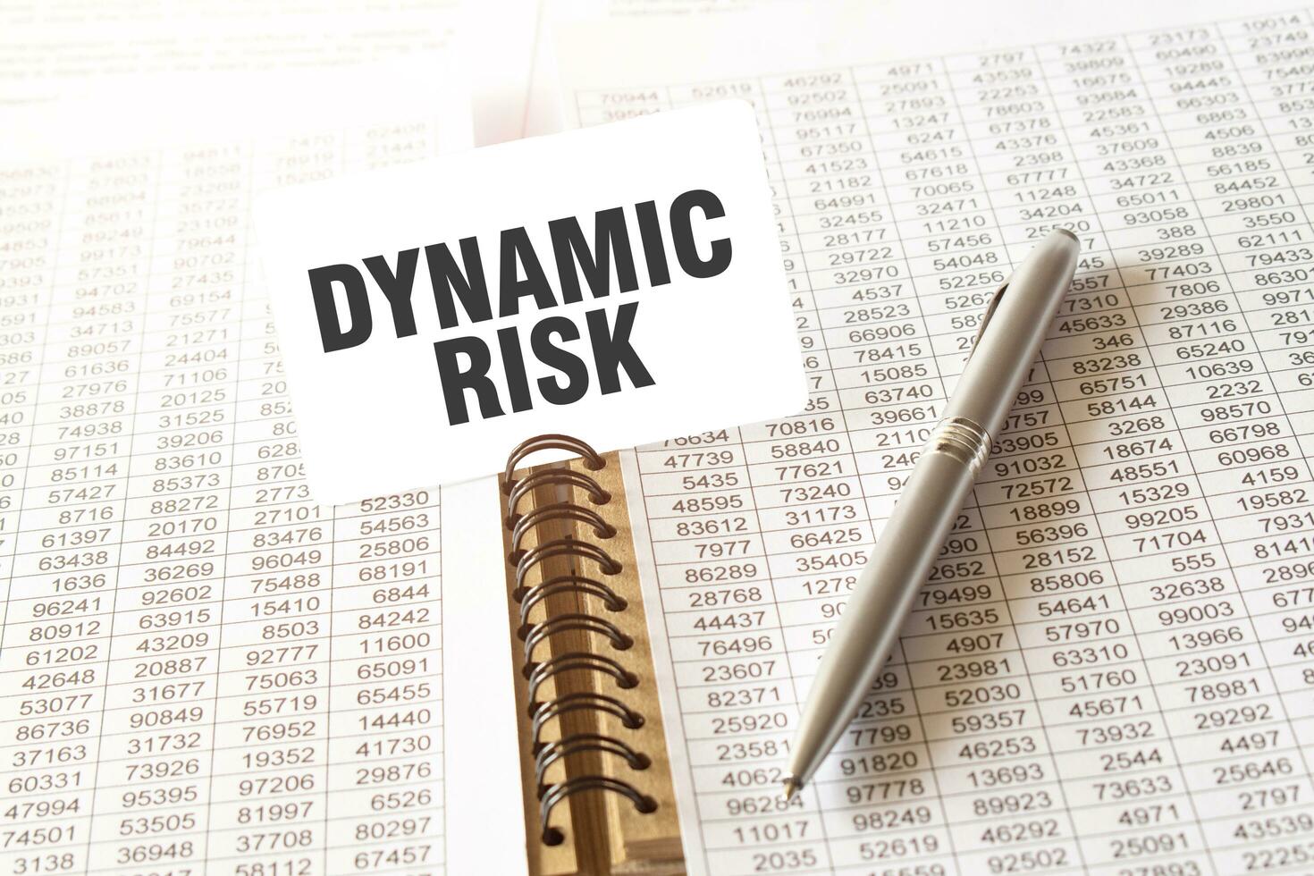 text dynamisk risk på papper kort, penna, finansiell dokumentation på tabell foto