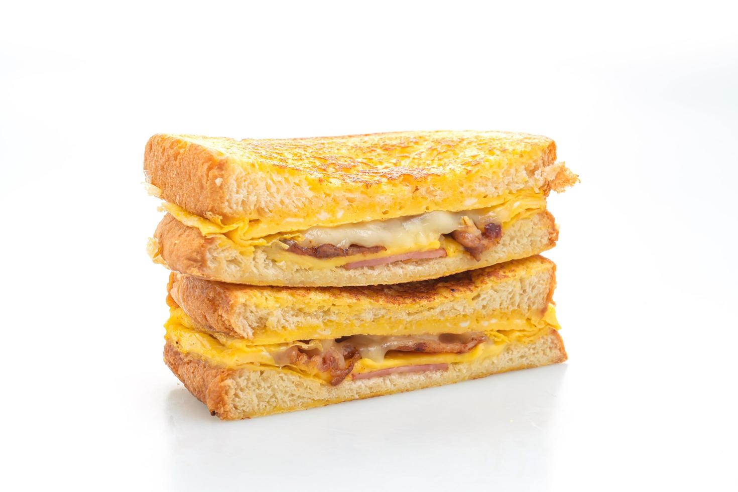 fransk toast skinka, bacon och ostsmörgås med ägg isolerad på vit bakgrund foto