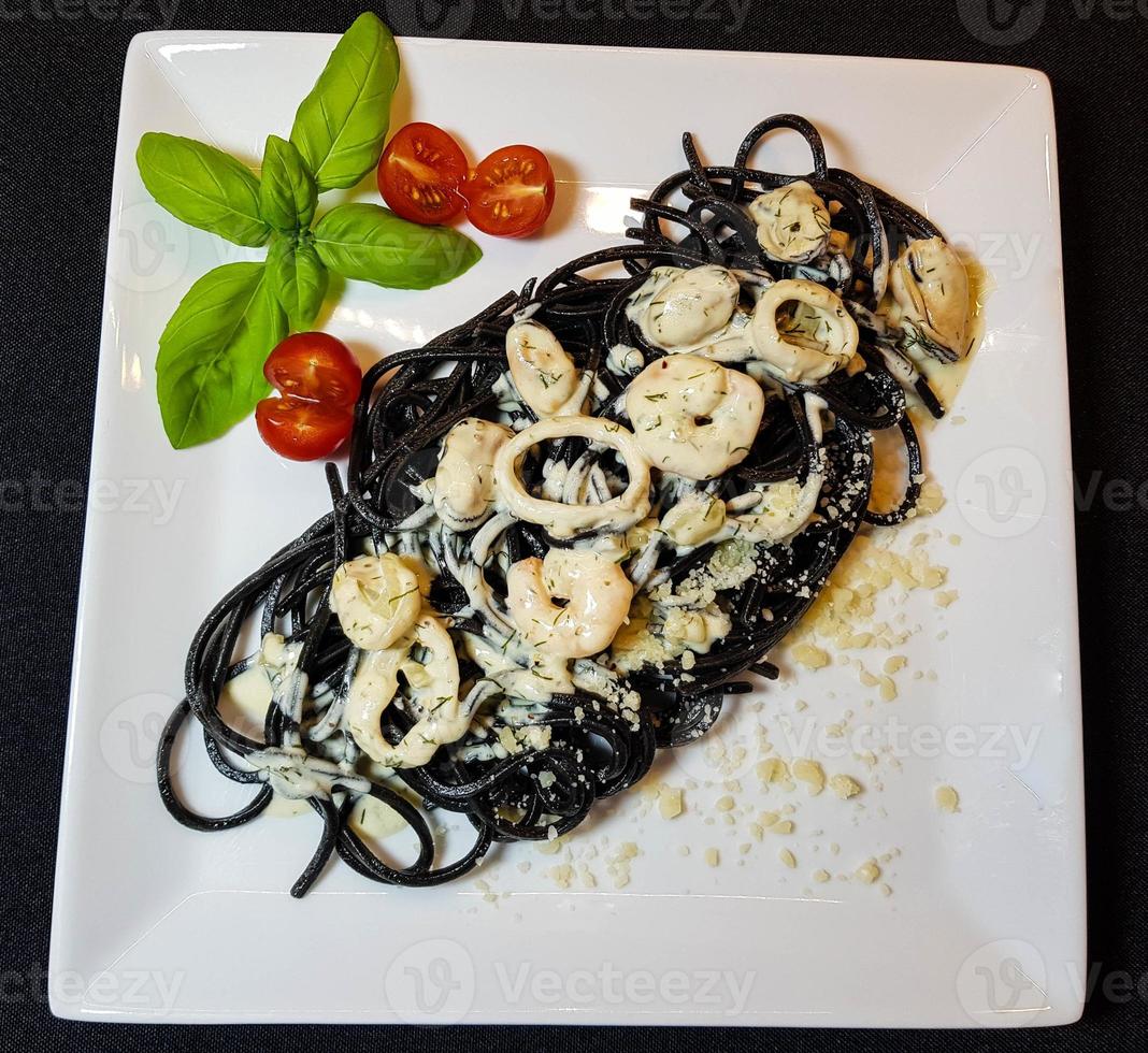 spaghetti rigate - svart pasta med blandad skaldjur foto
