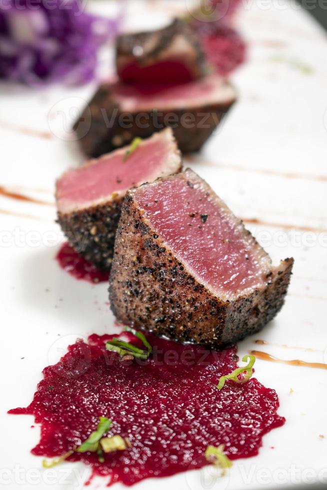 gourmetbränd tonfisk i svartpepparskorpa med rödbetor och halloncoulis foto