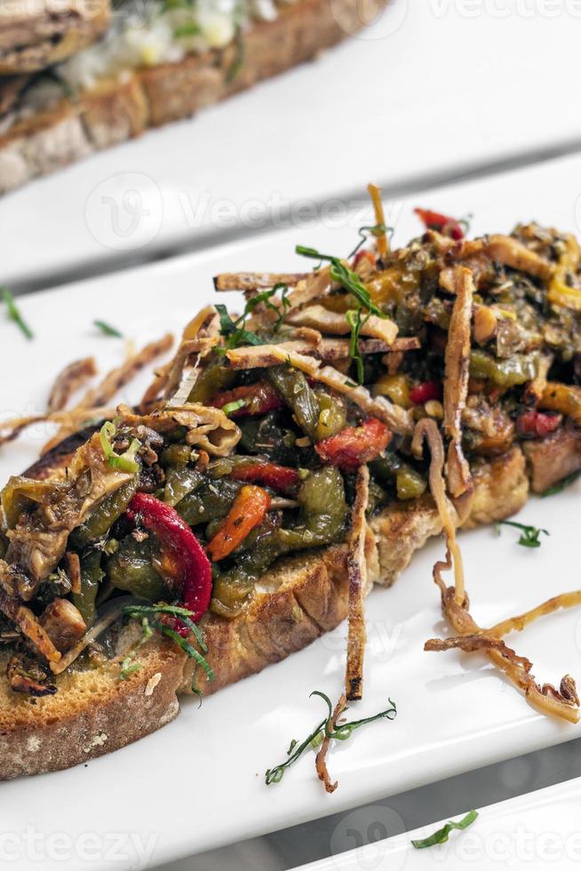 kryddig torkad bläckfisk och rostade grönsaker rostade smörgås tapas mellanmål i Portugal foto