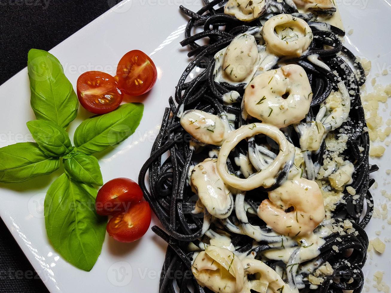 spaghetti rigate - svart pasta med blandad skaldjur foto