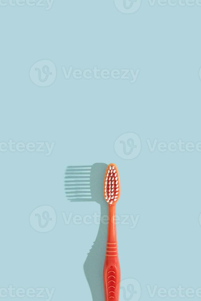 rosa tandborste på blå bakgrund med hård skugga. dental vård begrepp. foto