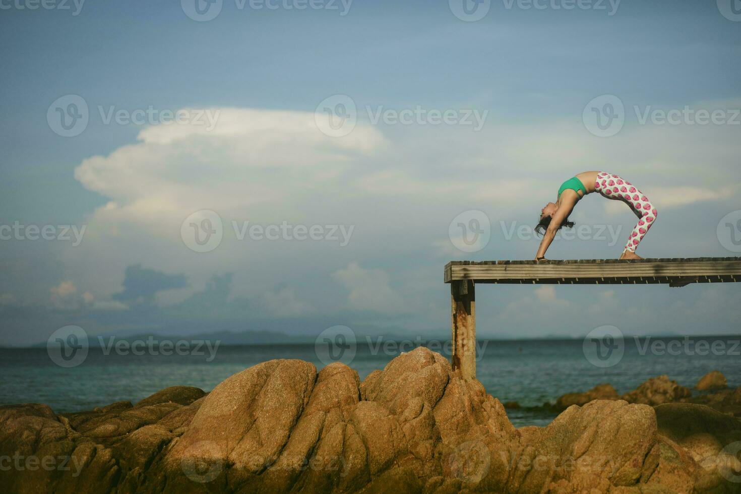 hälsa kvinna avkopplande och spelar yoga utgör på strand pir foto