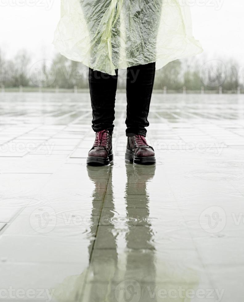 kvinna som går i regnet, står i pölar foto