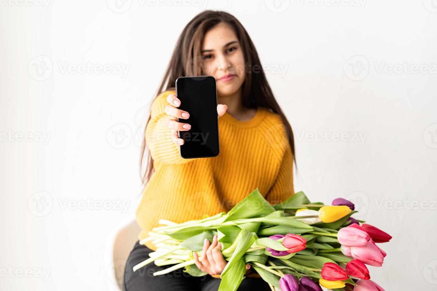 färska rosa tulpaner och tom mobiltelefon för hån foto