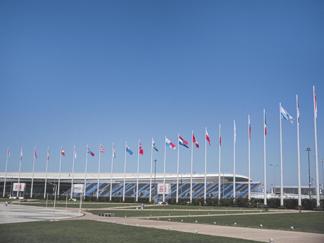 adler city, ryssland - augusti 2019, flaggor i världens länder på flaggstänger i olympiska parken foto