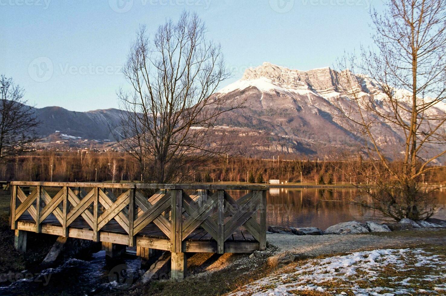 lugn skönhet blå sjö i savoie med snö capped bergen foto