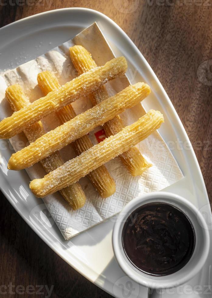 churros con choklad traditionell spansk söt frukost på träbord foto