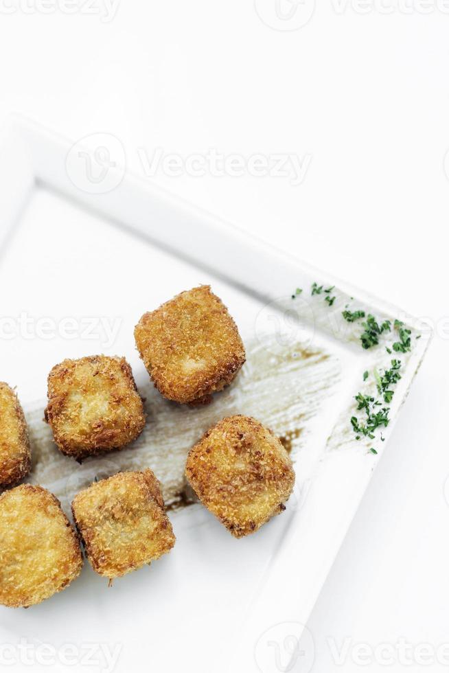 stekt potatismos kvadratiska kroketter enkel vegetarisk sidrätt på vit tallrik foto