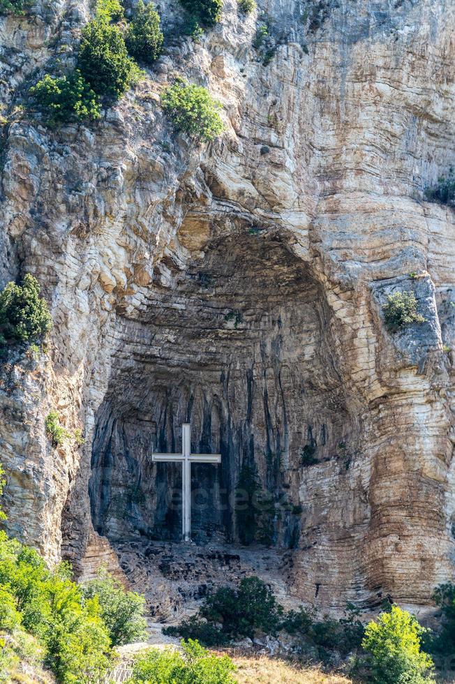 kors placerat i en nisch på ett berg foto