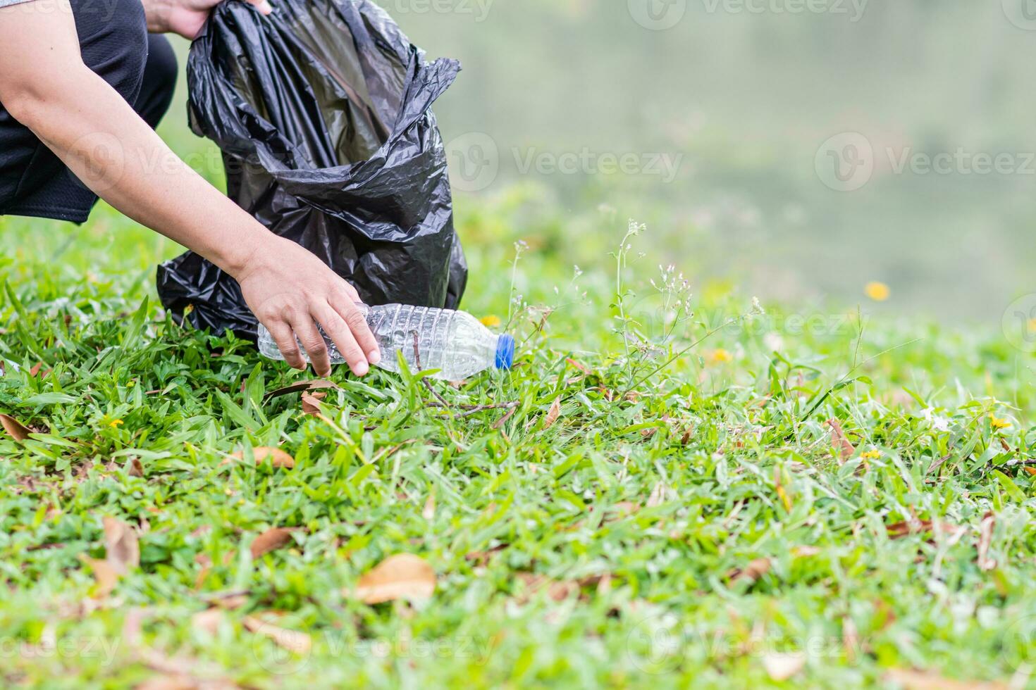 en kvinna rengör upp förbi plockning upp plast flaskor på en naturlig vatten reservoar. begrepp av skyddande de miljö, sparande de värld, återvinning, selektiv fokus. stänga upp, suddig bakgrund foto