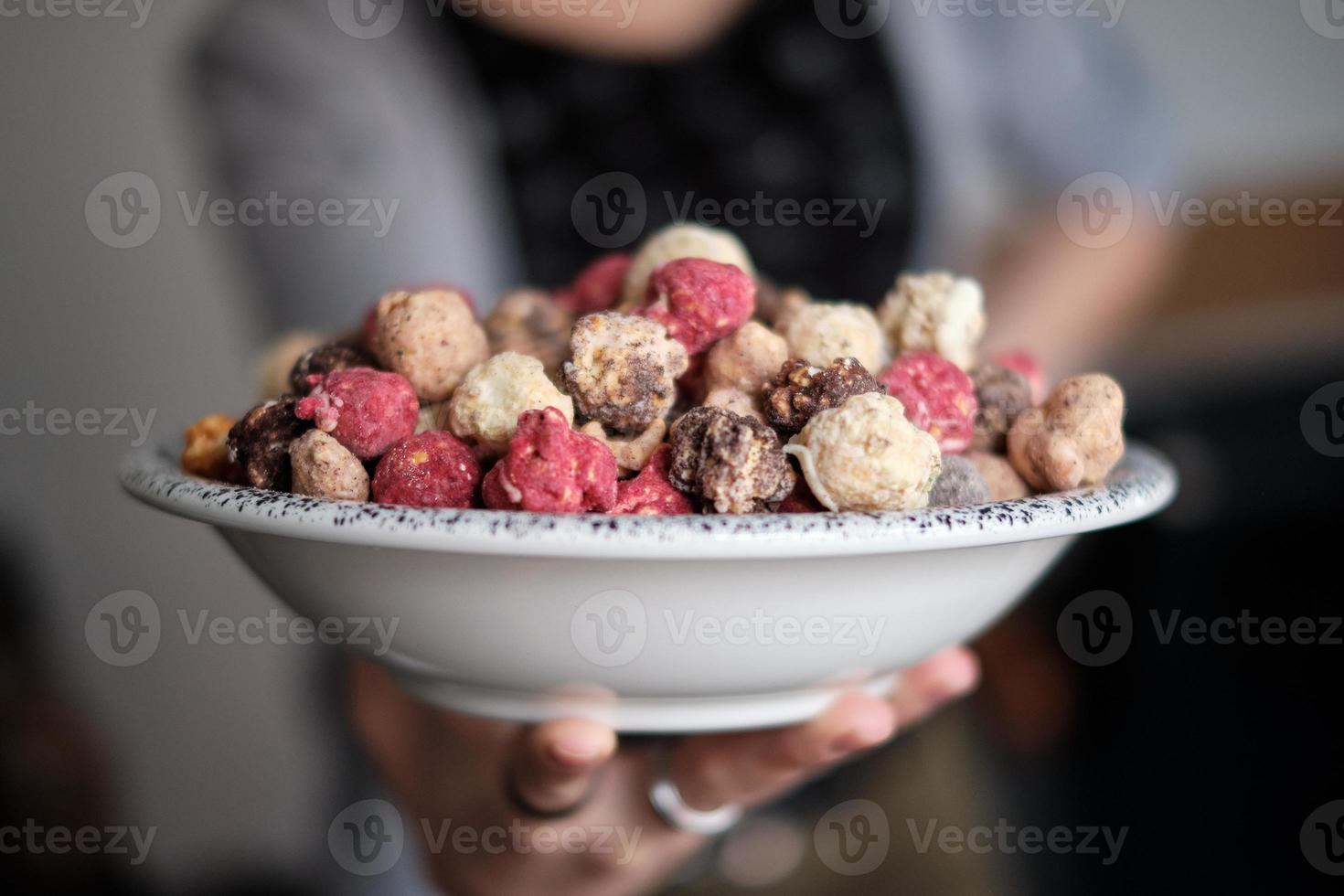 person som håller en skål med söta färgglada popcorn foto