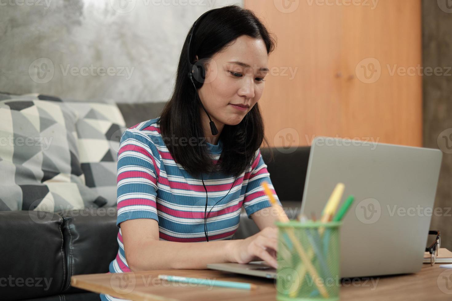 asiatisk kvinna som använder bärbar dator för arbete hemifrån och online -lärande. foto